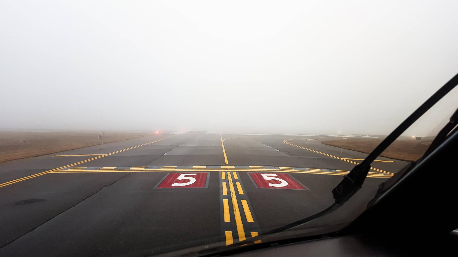 View from an aircraft cockpit toward a runway in low visibility